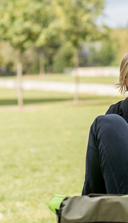 Drei Personen sitzen im Park