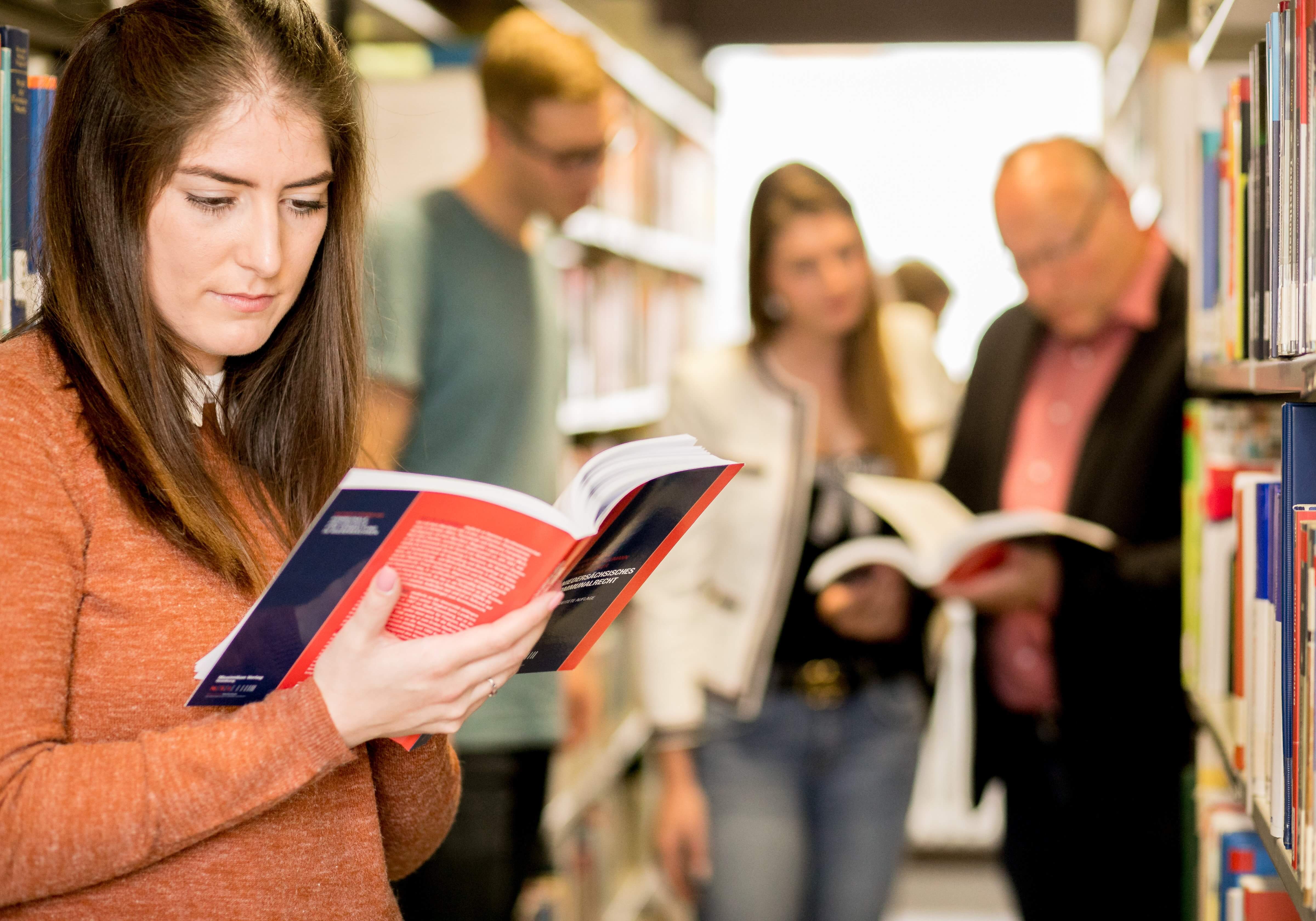 Personen in Bibliothek beim Lesen